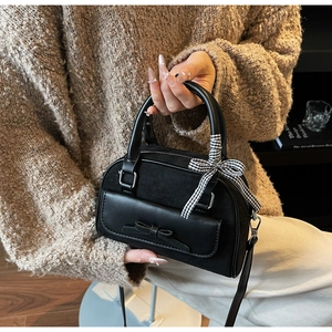 Detail of black matte shoulder bag with 3D bow, silver hardware and check ribbon