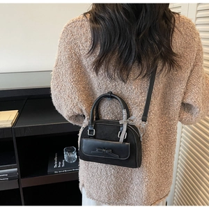 Fashionable black matte crossbody bag with bow and plaid ribbon on model