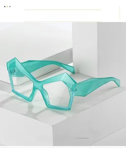 Dettaglio degli occhiali da sole cat-eye geometrici in verde trasparente su blocchi bianchi
