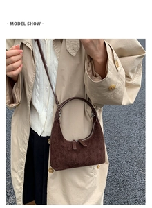 Deep brown suede crescent bag styled with a beige trench coat for a chic vintage look