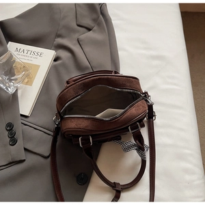Vista superior del bolso bandolera vintage marrón oscuro con doble cremallera y lazo de cuadros