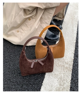 Detail of dark brown and caramel suede crescent bags with a matte leather texture