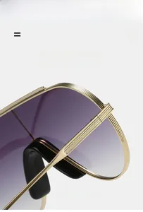 Close-up of golden metal sunglass frame with vertical textures and purple gradient lens