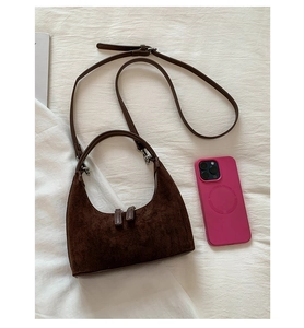 Macro detail of brown matte suede hobo bag with dual zipper and adjustable shoulder strap
