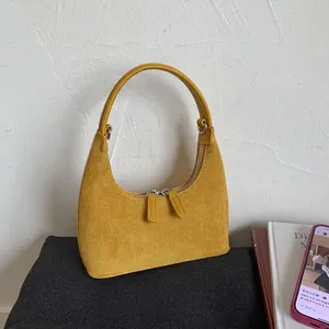 Mustard yellow suede half-moon shoulder bag with sleek leather handle and silver zippers