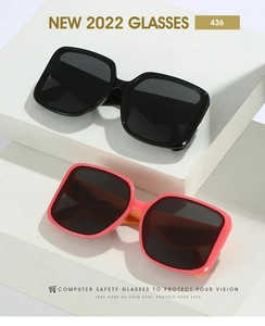 Detail of square oversized sunglasses in black and pink frames on white props