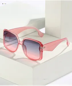 Detail of pink square sunglasses with purple gradient lenses on a stone pedestal
