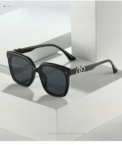 Detailed close-up of square black sunglasses with silver interlocking ring decor on temple