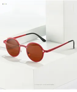 Detail of red round frame sunglasses with dark brown lenses on geometric white blocks