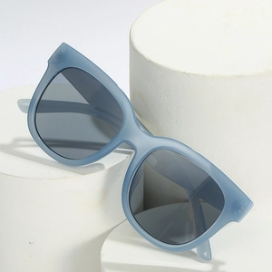 Stylish light blue cat-eye sunglasses with dark grey lenses on white display pedestals