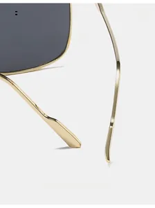 Détail des branches en métal doré incurvé sur des lunettes de soleil carrées oversize