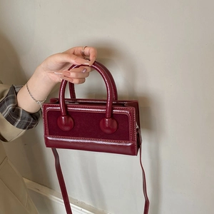 Wine red small bucket bag in glossy and suede leather with top handle and strap