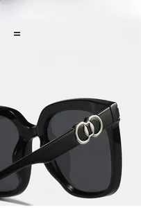 Macro detail of square sunglasses with silver double-ring metal hinges and black frame