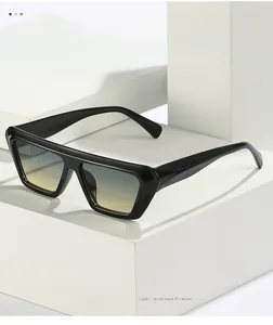 Detailed close-up of retro black square sunglasses with gradient lenses on white props