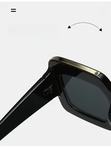 Detail shot of durable metal hinge on black oversized sunglasses with gold top bar inlay