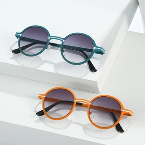 Retro round frame sunglasses with gradient lenses in blue and orange on geometric display