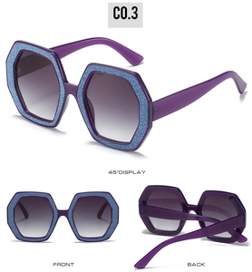 Dettagli di occhiali da sole poligonali viola con glitter blu sui bordi delle lenti