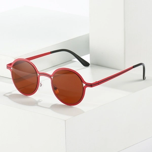 Retro round metal sunglasses with vibrant red frames and dark brown lenses on white blocks