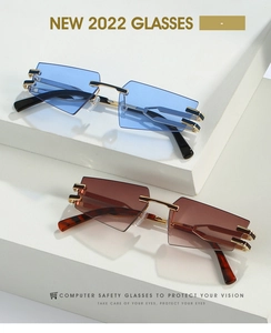 Detail view of cat eye rimless sunglasses with blue and tea gradient lenses on white cubes