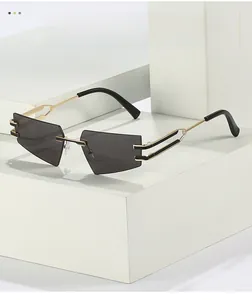 Detail of dark grey geometric rimless lenses and gold metal temples with hollow design