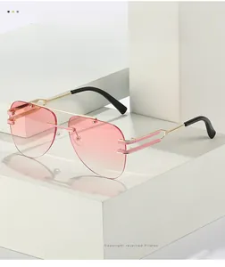 Détails des verres dégradés roses et branches en métal doré sur lunettes pilote sans bord
