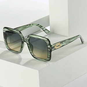Lunettes de soleil carrées oversize avec monture rayée verte et verres dégradés de mode