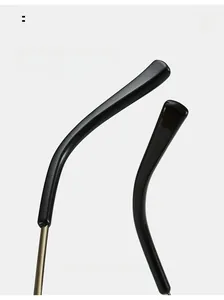 Close-up of curved black temples with gold metal hinges on cat eye rimless sunglasses