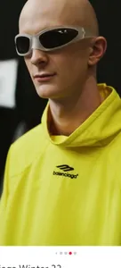 Close-up of wraparound silver sports sunglasses with black lenses on a yellow hoodie