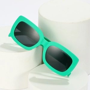 Lunettes de soleil rectangulaires rétro avec monture verte et verres foncés sur socles