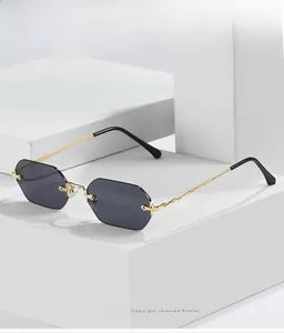 Detail view of octagon rimless sunglasses with gold metal frame and dark grey lenses