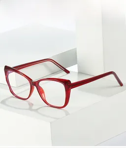 Vue détaillée d'une monture de lunettes œil-de-chat rouge translucide sur blocs blancs