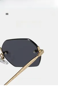 Close-up of gold metal temple with geometric engraving on rimless polygon sunglasses