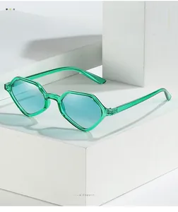 Detail of geometric green frame sunglasses with blue lenses on a white block