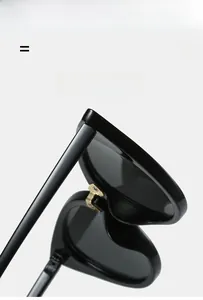 Detail of golden metal hinge on black geometric sunglasses with thick frame