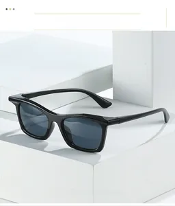 Close-up of black frame sunglasses showing premium material texture on stone display