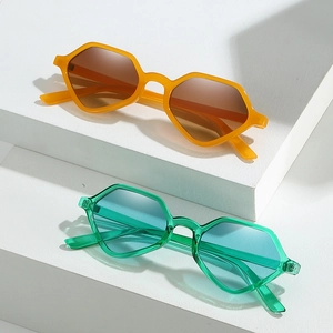 Retro geometric hexagonal sunglasses in orange and green tones on a white stage