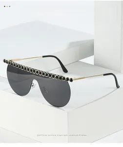 Macro detail of rimless sunglasses featuring luxury rhinestones and gold metal temples