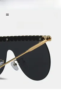 Detailed view of the gold metal hinge and rhinestones on these oversize flat top sunglasses