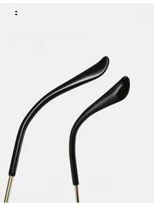 Close-up of curved black temple tips and golden metal arms on oversized sunglasses