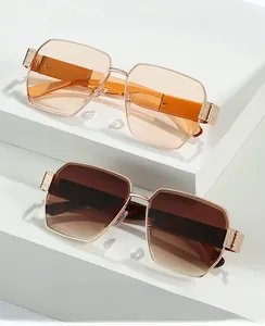 Detail of square rimless sunglasses with orange and brown gradient lenses on white stone