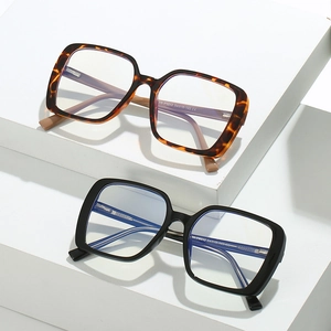 Retro oversized TR anti-blue light glasses with black and tortoiseshell frames on steps