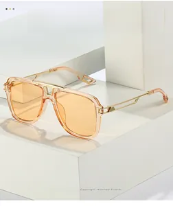 Détail de lunettes de soleil carrées orange avec branches en métal doré ajouré