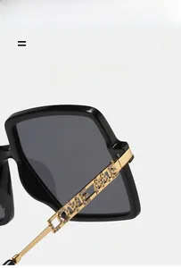 Detail of gold metal temples with rhinestone LOVE lettering on oversized sunglasses