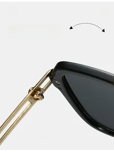 Détail de la charnière en métal doré sur lunettes de soleil carrées à monture noire solide