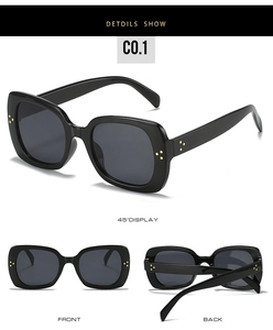 Detail view of black square sunglasses with gold rivet accents on frame and temples