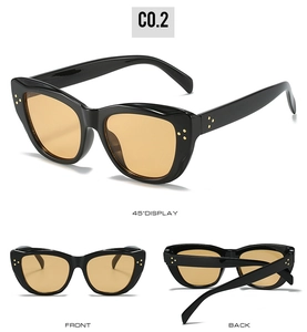 Detailed view of black cat-eye sunglasses with yellow lenses and triple gold rivet accents