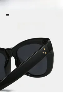 Detailed macro of cat eye sunglasses hinge with triple golden rivets on black frame