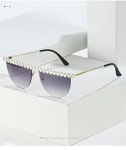 Détail de lunettes de soleil demi-cerclées avec verres dégradés violets et strass