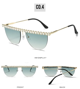 Détail de lunettes de soleil de luxe avec branches dorées et verres verts strassés