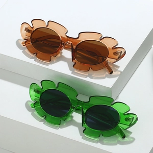 Leaf-shaped cat eye sunglasses in amber and green translucent resin with floral frame details